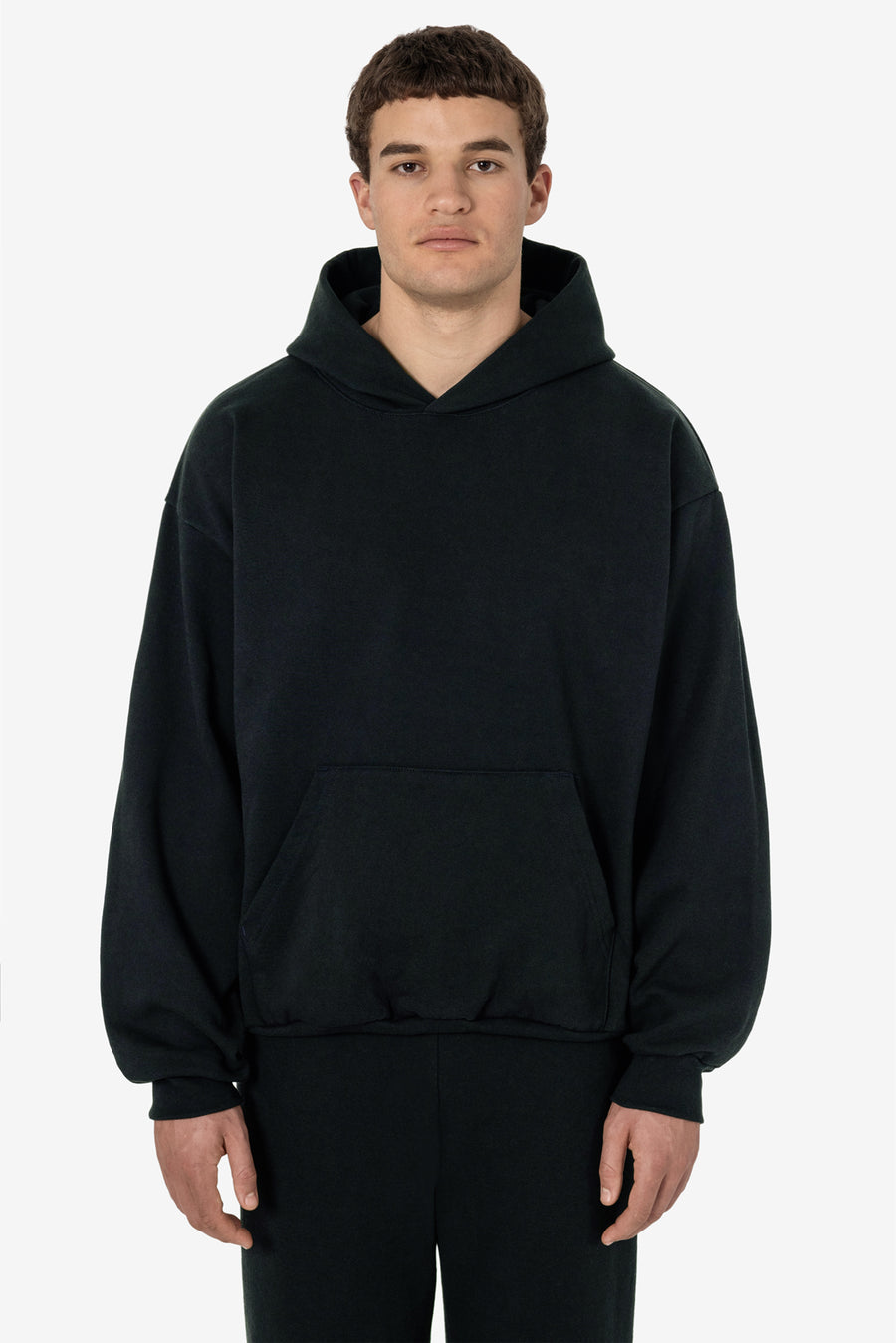 Model wearing a navy Los Angeles Apparel 14 ounce Heavy Fleece Hoodie as the insulating middle layer