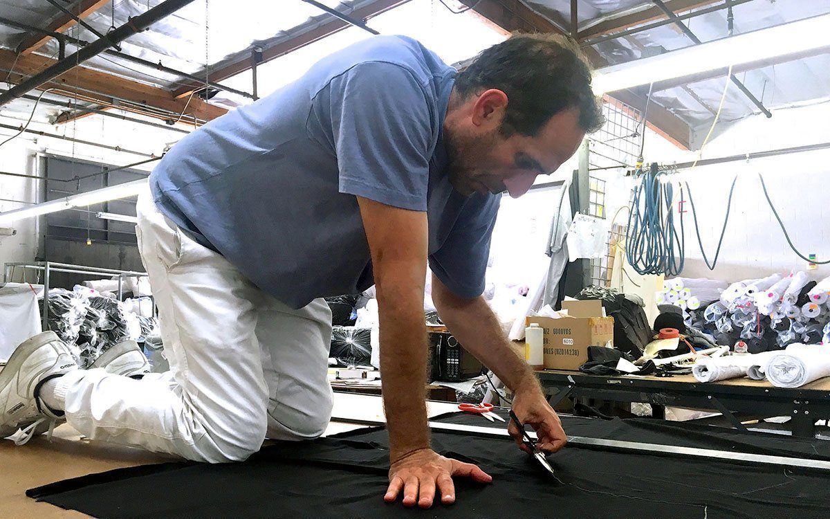 Dov Charney cutting fabric inside Los Angeles Apparel production in Los Angeles.