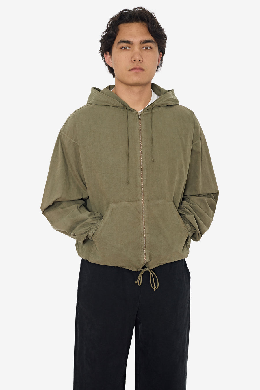 Model wearing an army cotton poplin zip-up hooded jacket as an outer layer